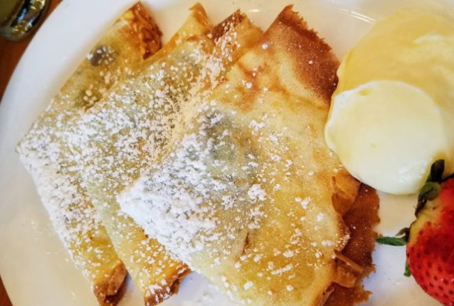 House-made crêpes with powdered sugar and strawberries