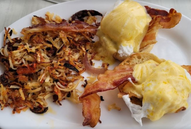 Eggs Benedict with hash browns and bacon