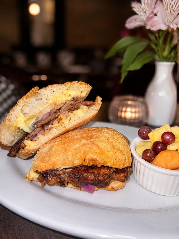 Breakfast sandwich served with a side of fresh fruit